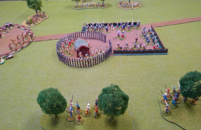 A tabletop miniatures game setup with colonial troops protecting a fort from French and Indian attack.